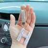 A hand holds a crystal letter keychain charm shaped like the letter H.