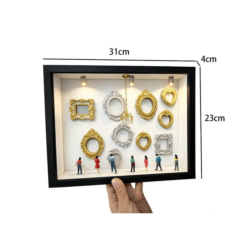 Schwarze Präsentationsbox mit Silhouettenrahmen aus Gold und Silberharz sowie einem hängenden goldenen Stück