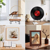 A set of metal display easels holding various items like plates, photos, and collectibles on a wooden surface.