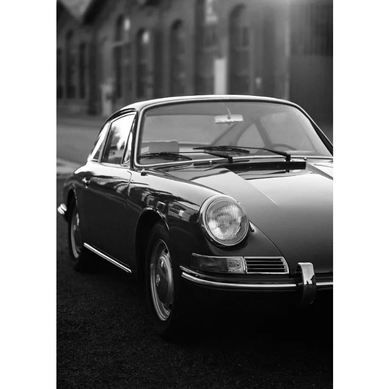 Ein schwarzes Luxusauto im Profil vor einem unscharfen Hintergrund.