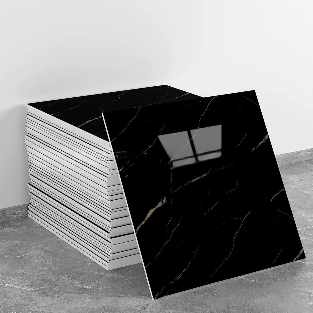 A stack of black marble tile stickers with gold veining displayed on a gray surface.