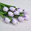 A bouquet of realistic artificial tulips in shades of lavender and white on green stems.