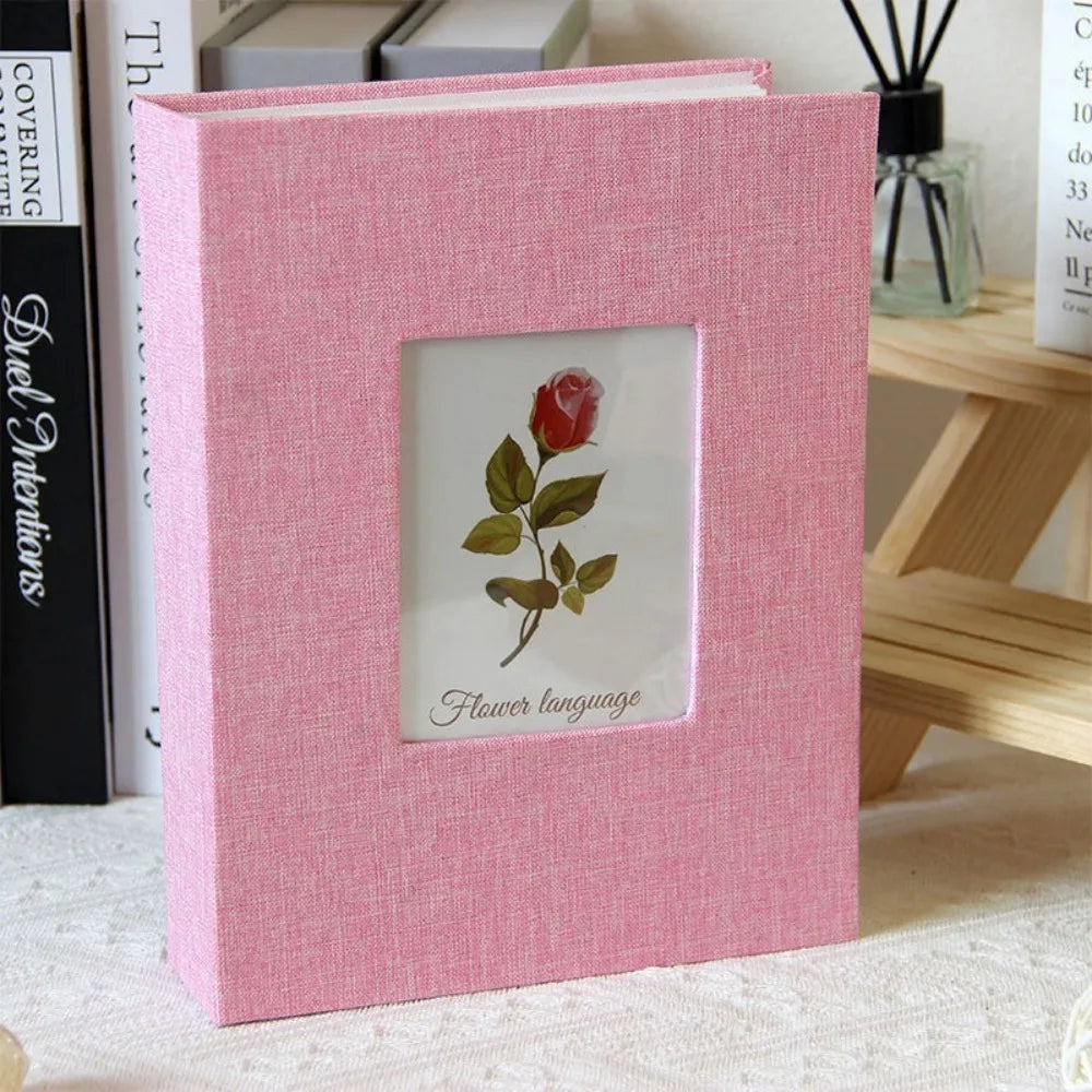 A pink linen cover photo album with a square window displaying a red rose and the text Flower language.