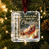 Clear acrylic ornament featuring a festive Christmas scene with reindeer and gifts, suspended by a velvet ribbon.