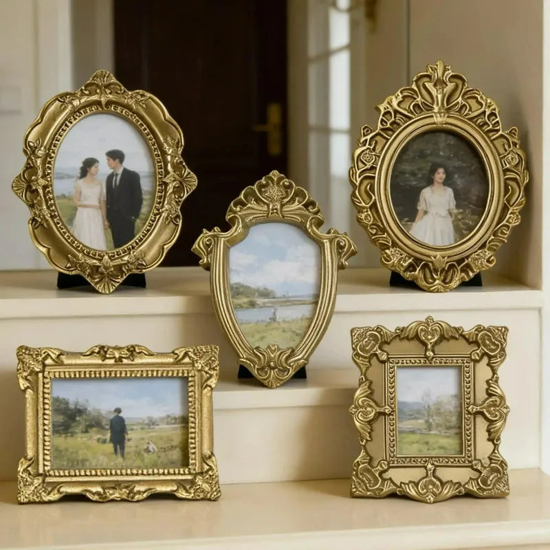 A collection of vintage gold-framed resin mini photo frames displayed on a white shelf.