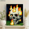 A pixel art print of a skull engulfed in bright orange and yellow flames against a dark background.