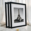 A set of three black photo frames displaying a black and white image of the Eiffel Tower.