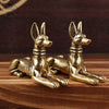 Handmade Egyptian Pharaoh dog statue in gold color resting on a wooden surface.
