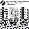 A set of cow print number foil balloons, plates, cups, napkins, and a tablecloth for a farm-themed party.