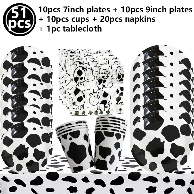 A set of cow print number foil balloons, plates, cups, napkins, and a tablecloth for a farm-themed party.