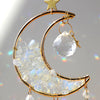 A gold dreamcatcher featuring a crescent moon made of clear quartz crystals and a star charm.