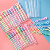 A collection of heart-shaped bubble wands in various pastel colors, including pink, yellow, and green, arranged on a light bl