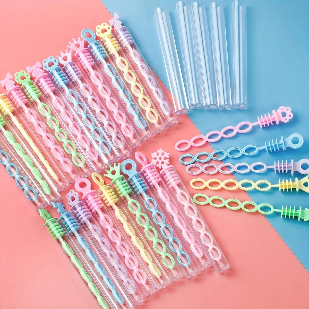 A collection of heart-shaped bubble wands in various pastel colors, including pink, yellow, and green, arranged on a light bl