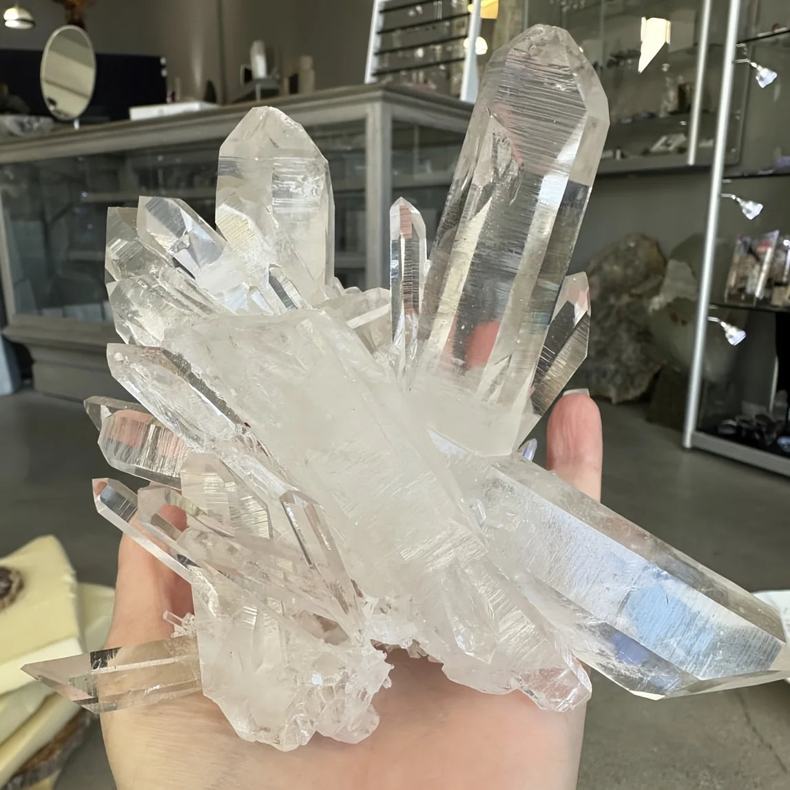 A cluster of clear quartz crystals displayed in a hand for home decor.