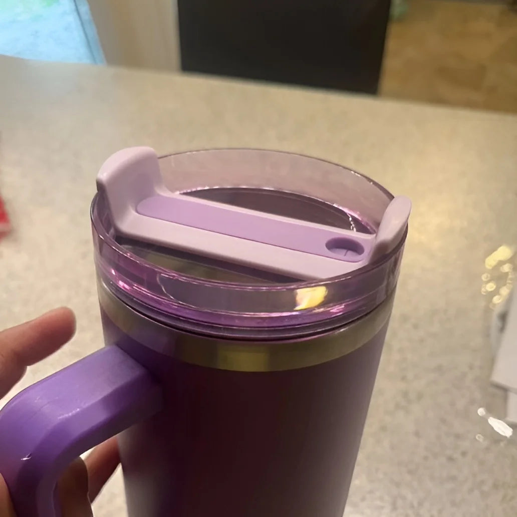 A purple replacement tumbler lid with a silicone cover is shown on a light countertop.