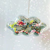 A hanging ornament shaped like a cloud, made of multicolored mosaic glass pieces.