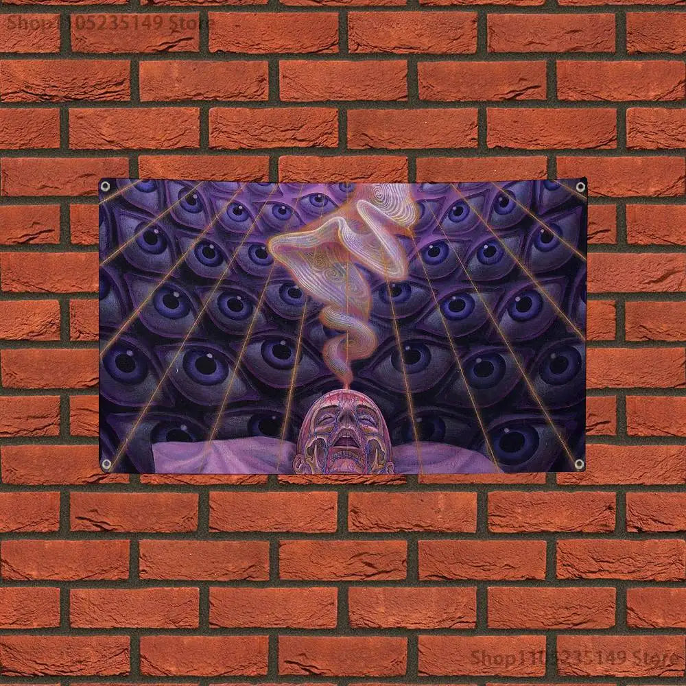 A tapestry featuring a pattern of many eyes and a face emerging from the center, displayed against a brick wall.