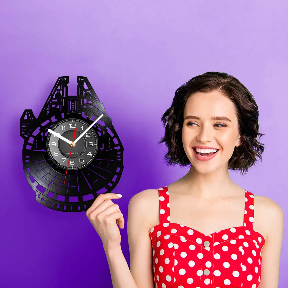 A black vinyl record wall clock is displayed against a purple background next to a smiling woman wearing a red polka dot top.