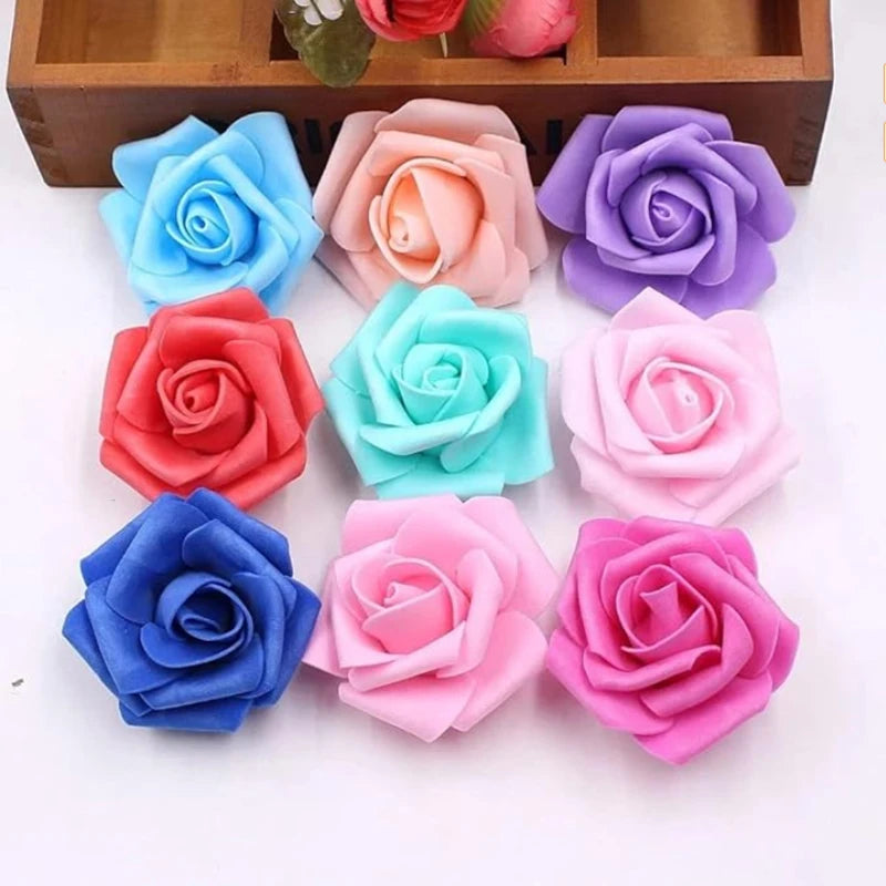 A collection of artificial foam roses in various shades of blue, pink, and purple arranged on a wooden tray.