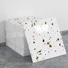 A stack of faux marble 3D self-adhesive wall tiles with multicolored flecks displayed on a gray surface.