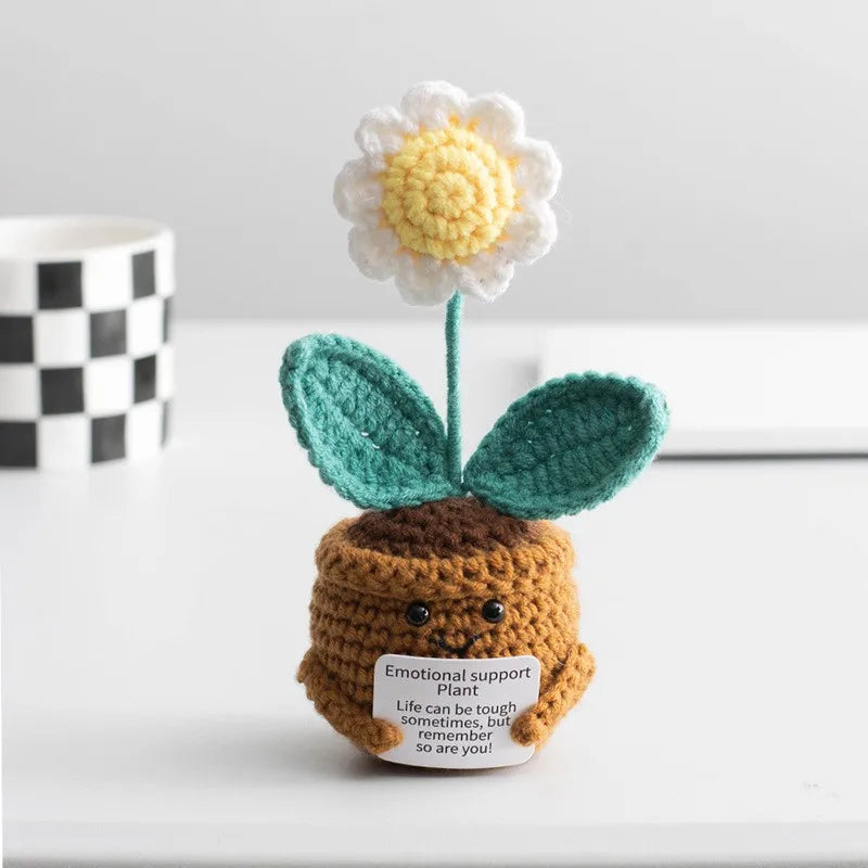 Handmade crochet sunflower desk companion with a smiling face, featuring white and yellow petals on a green stem.