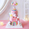A pink unicorn theme cake topper set featuring a multi-tiered cake decorated with pastel colors and rainbow accents.