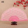 Pink lace folding hand fan with a fan shape and decorative base against a beige background.