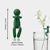 A set of three green human-shaped plant supports used for hydroponic growth, shown next to a glass.
