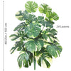 A lush artificial monstera plant with variegated green and white silk leaves shown against a white background.