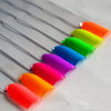 A set of thirteen vivid neon fluorescent pigment powders arranged in a row on a white surface.