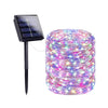 A spool of colorful LED fairy string lights with a solar panel attached for outdoor decoration.