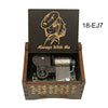 A dark wooden box containing a mechanical music box with an anime-style character design.