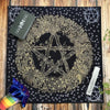 A black cloth featuring a gold pentagram design surrounded by a wreath of foliage and stars.