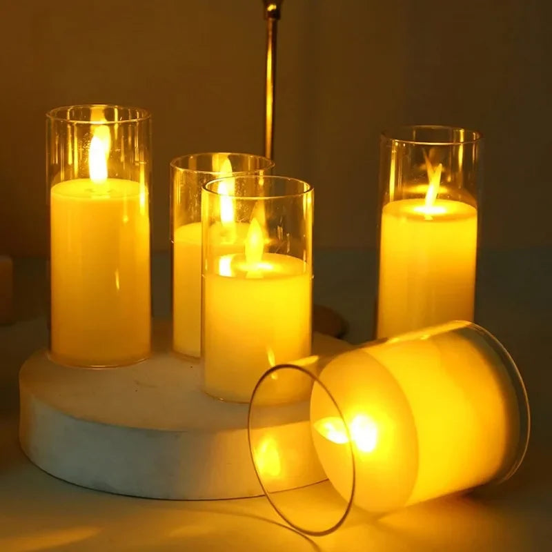 A collection of glowing yellow LED candles in glass holders with flickering flames on a white surface.