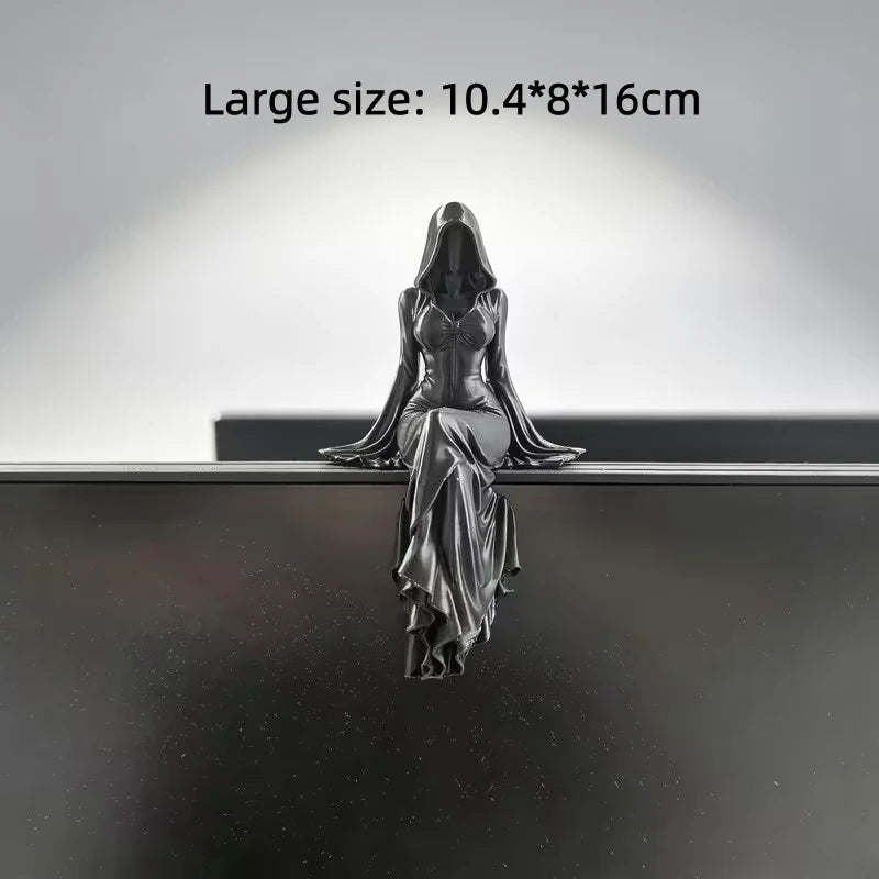 A silver-colored desktop figurine of a female figure in a flowing gown, displayed against a dark background.