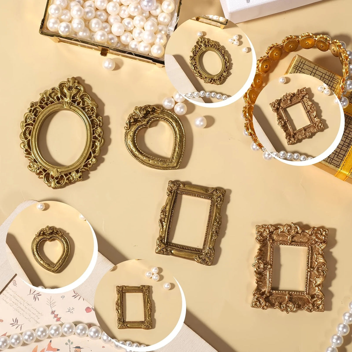 A collection of miniature vintage gold picture frames and pearl beads arranged on a light beige surface.