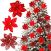 A set of six red glittered artificial Christmas flowers with clips displayed against a snowy evergreen tree.