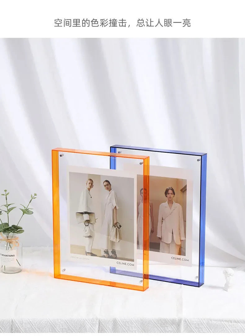 Zwei moderne Acryl-Foto-Displayrahmen, einer orange und einer blau, auf einer weißen Oberfläche.