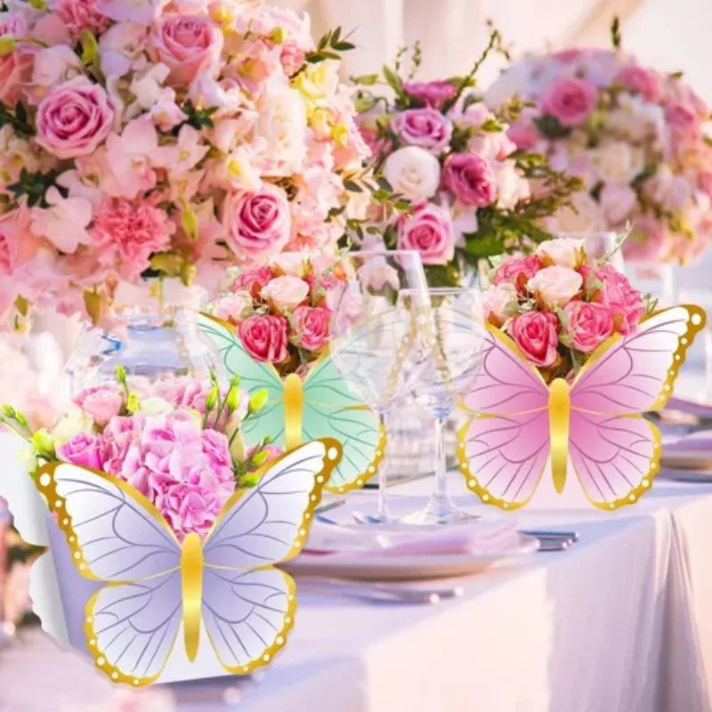Pink and white floral arrangements and butterfly decor on a table setting for a garden party.