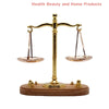 A vintage miniature balance scale with a brass cross and wooden base.
