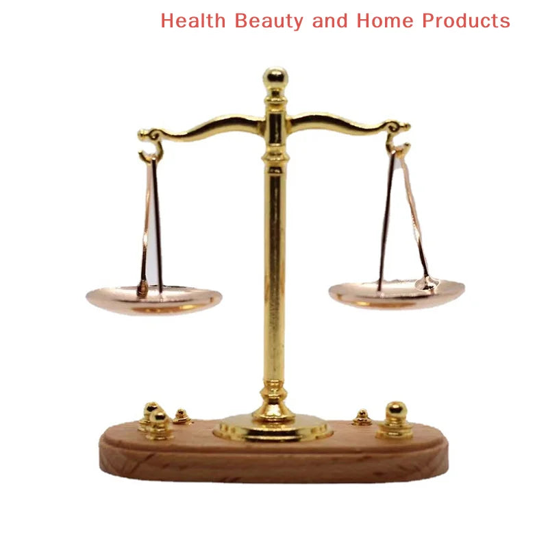 A vintage miniature balance scale with a brass cross and wooden base.