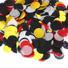 A pile of round tissue paper confetti dots in black, red, and yellow colors.