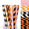 A vertical arrangement of colorful striped and polka dot paper drinking straws in various shades of orange, pink, and black.