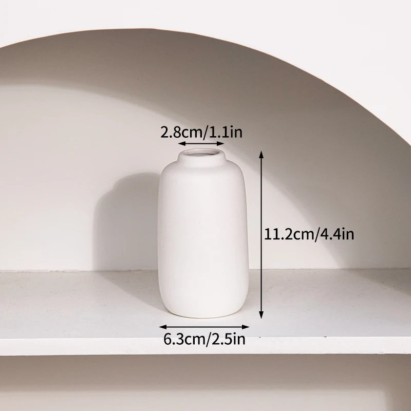 A white ceramic vase is displayed on a shelf, showing its dimensions.