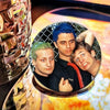 A set of collectible brooches featuring three male figures against a fiery background.