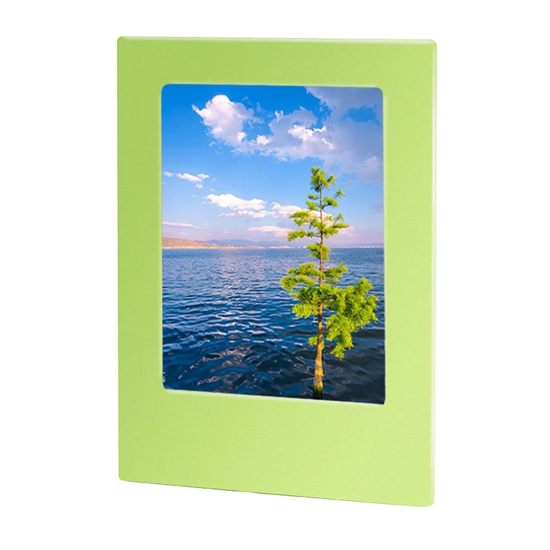 A light green magnetic double-sided frame displaying a scenic view of a blue lake with a pine tree and clouds.