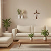 A handcrafted wooden cross wall decor displayed on a light-colored wall above a sofa and coffee table.