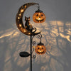 A solar-powered pumpkin moon garden stake light featuring a crescent moon shape and hanging jack-o'-lantern lights.