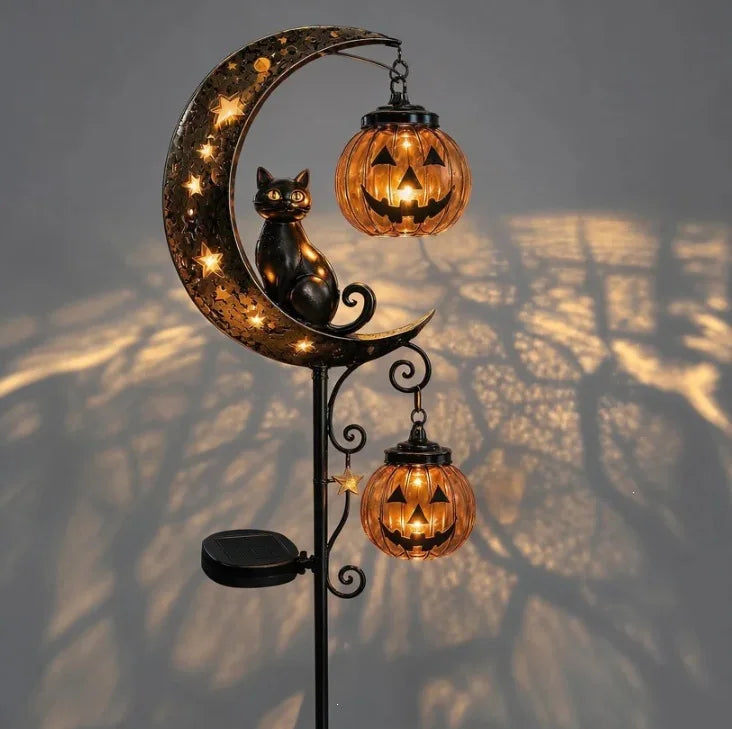 A solar-powered pumpkin moon garden stake light featuring a crescent moon shape and hanging jack-o'-lantern lights.