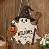 A wooden ghost door hanging featuring a witch hat and a broom, with the word welcome carved into the design.